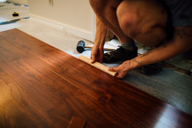 a home contractor installing dark wood flooring
